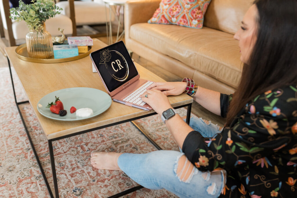 Christina Rose typing on a pink laptop showing her CR logo, symbolizing ADHD family coaching, ADHD home organization, and ADHD systems for families.