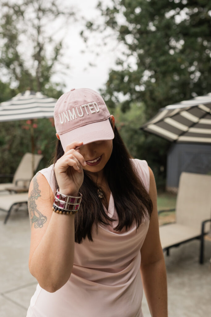 Christina Rose wearing a pink “Unmuted” hat, representing empowerment through ADHD family coaching, ADHD home organization, and ADHD systems for families.